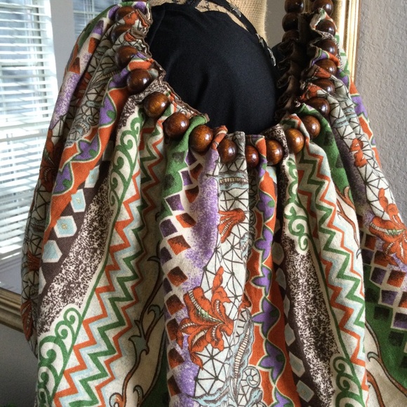 Reversible hobo tote with brown wood balls straps. Has a tie strap closure. - Picture 5 of 10